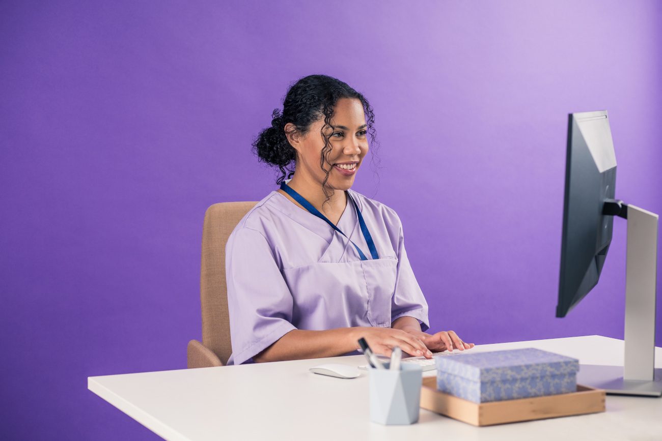Lääkäri istuu tietokoneen ääressä.