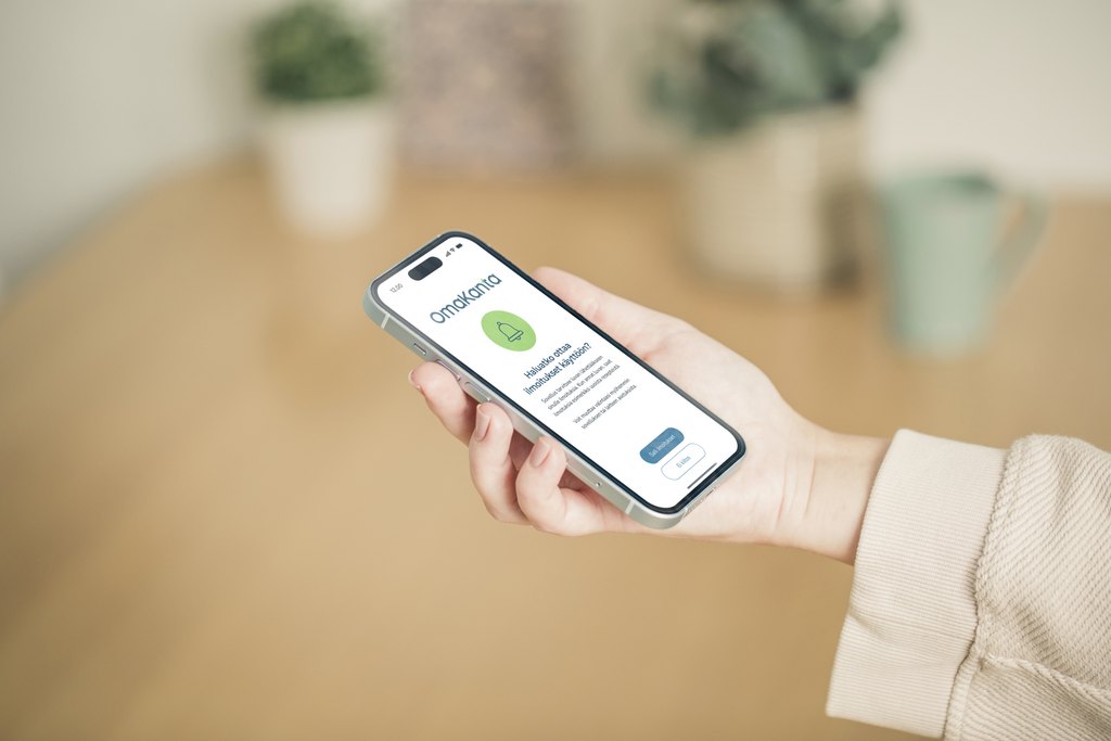 På bilden syns en hand och en telefon, på vars skärm MittKanta-appen visas.